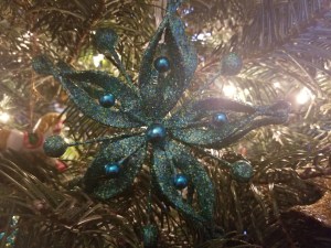 A sparkly teal star on a Christmas Tree. 